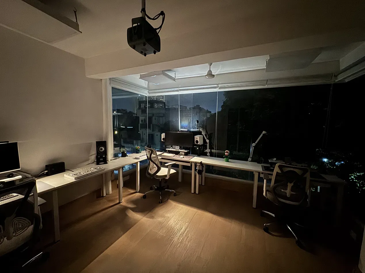 The room at night, both stations lit, city through the glass